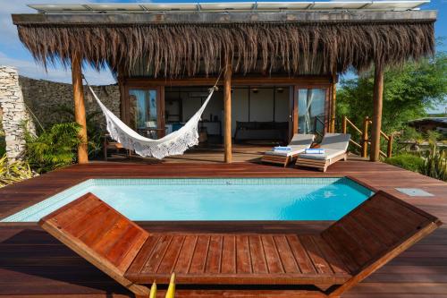 a hammock on a deck next to a swimming pool at Soledade Bangalôs - Kauli Seadi in Macau
