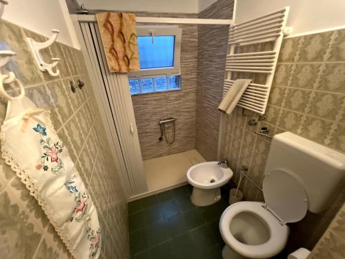 Un baño pequeño con inodoro y lavabo. en Modica house with a view of Etna, en Gravina di Catania