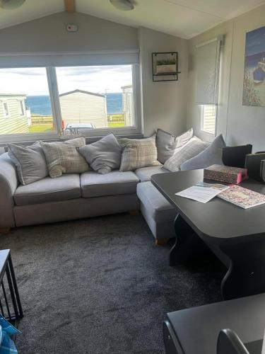 a living room with a couch and a large window at Crimdon Beachside Holidays in Hart