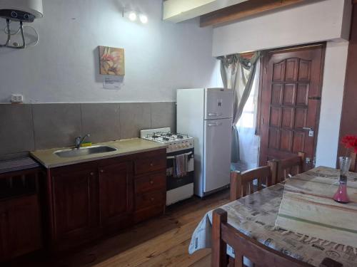 eine Küche mit einem Herd, einer Spüle und einem Kühlschrank in der Unterkunft clara mar in Santa Clara del Mar