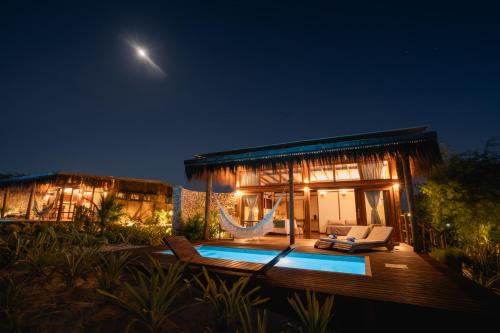 a villa with a swimming pool at night at Soledade Bangalôs - Kauli Seadi in Macau