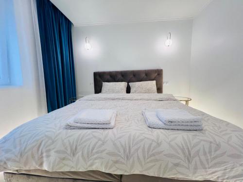 une chambre avec un grand lit avec deux serviettes dessus dans l'établissement Premium Apartment Turda, à Turda
