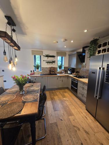 a kitchen with a table and a stainless steel refrigerator at Anna's Place in Totnes
