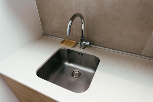 a kitchen sink with a faucet on a counter at Belgrade Waterfront Sky Apartment in Belgrade