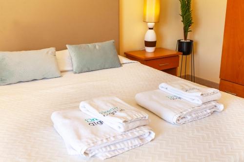 a bed with three towels on top of it at Quintão Apartment in Portimão in Portimão