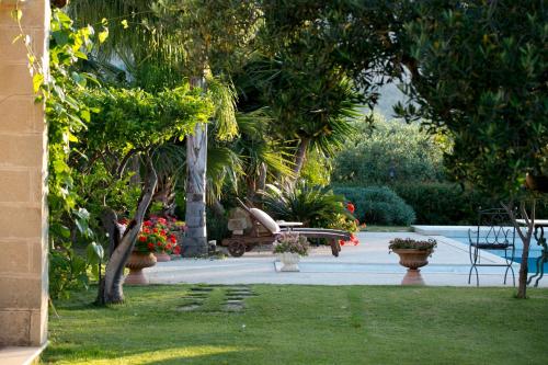 a garden with a bench and trees and plants at Baglio Sant'Andrea in Valderice