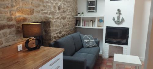 a living room with a chair and a fireplace at Charmante Maison Bretonne avec Piscine Chauffée in Plouguin