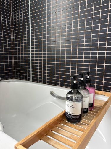 a bathroom with two bottles of soap and a bath tub at Quiet Asoke/Nana BTS Retreat w/ Skyline & Gym/Park in Bang Kapi