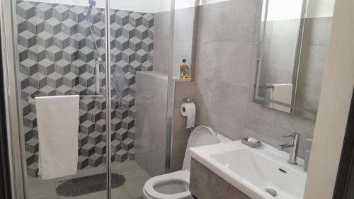 a bathroom with a shower and a toilet and a sink at West Coast Dream in Mauritius