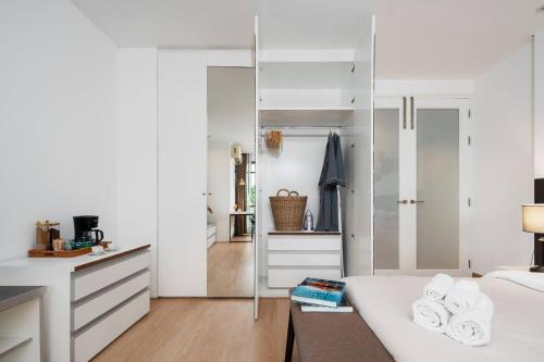 a bedroom with white walls and a bed with a mirror at Quiet Asoke/Nana BTS Retreat w/ Skyline & Gym/Park in Bang Kapi