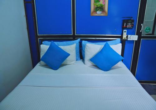 a blue and white bed with blue pillows at A4 Hostel Colombo Airport - travellers cottage in Katunayake