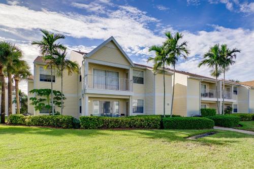 a house with palm trees in a yard at Walk to Beach 1st-Floor Unit with Pool in Melbourne in Indian Harbour Beach