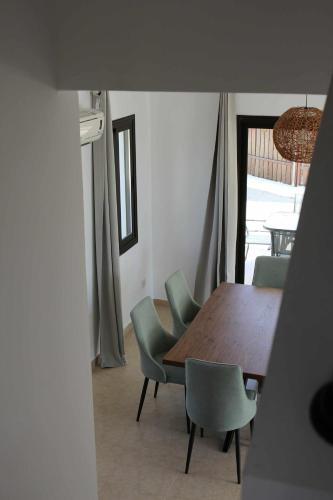 a dining room with a wooden table and green chairs at Casa Elea in Kouklia