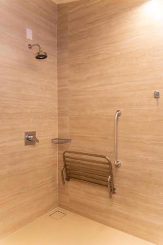 a bathroom with a shower with a wooden wall at Pousada Béni in Bananal