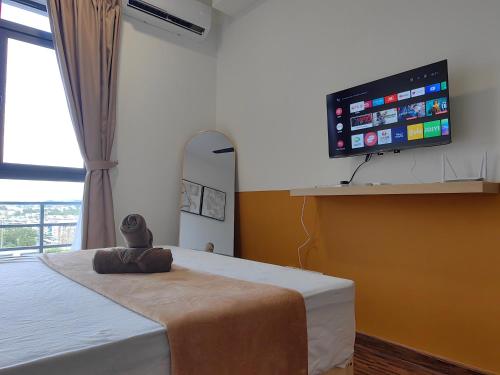 a bedroom with a bed and a flat screen tv at K Avenue Modern Style Studio (5 Mins to Airport) in Kota Kinabalu