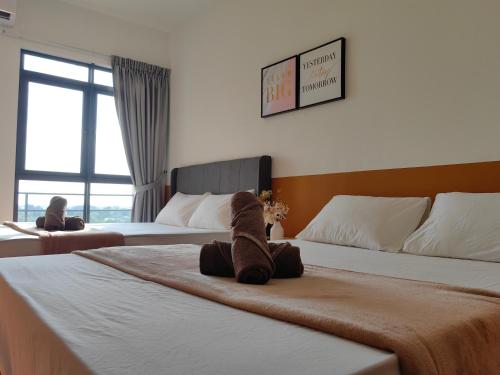 a hotel room with two beds with a teddy bear on it at K Avenue Modern Style Studio (5 Mins to Airport) in Kota Kinabalu