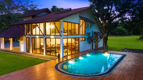 a house with a swimming pool in front of it at Clara Villas Amithirigala in Avissawella