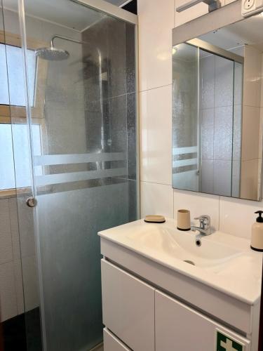a bathroom with a sink and a shower at Ohana Funchal in Funchal