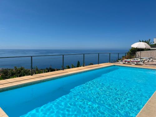a swimming pool with a view of the ocean at Casa Vista do Ledo in Arco da Calheta