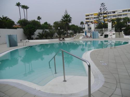 a large swimming pool with blue water in a resort at 6 building Aloe - Free WiFi, Central, near playa dunes in Maspalomas