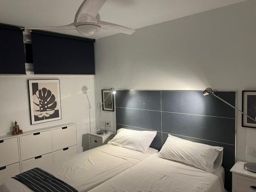 a bedroom with a large white bed with a black headboard at 6 building Aloe - Free WiFi, Central, near playa dunes in Maspalomas