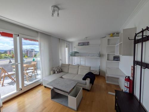 a living room with a couch and a balcony at Apartamento Carmen y Adolfo in Laredo