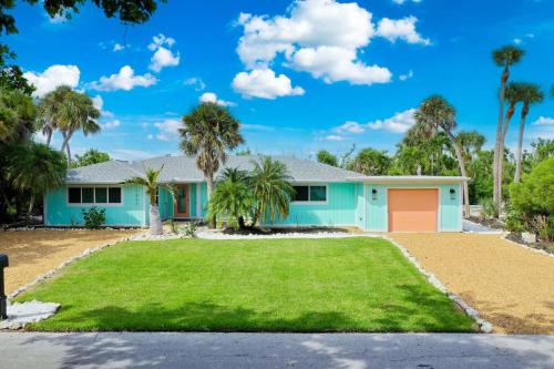 a house with palm trees in front of it at Sugarfish in Sanibel Island