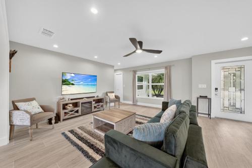 a living room with two couches and a tv at Sugarfish in Sanibel Island