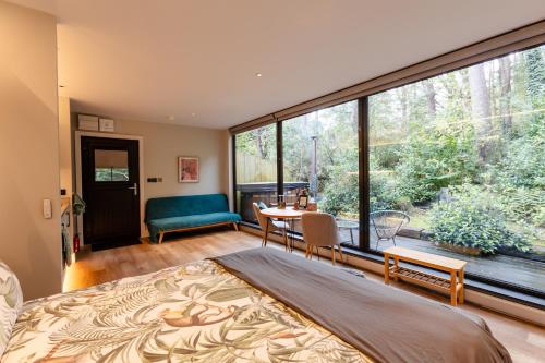 a bedroom with a bed and a large window at Burrenmore Nest - Luxury Forest Lodges with Hot Tubs & Sauna in Castlerock