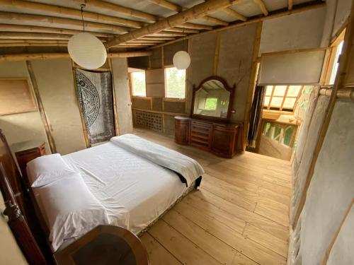 a bedroom with a bed and a mirror in it at Casa Bambú Veracruz in El Zapote