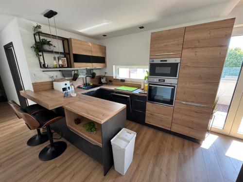 a kitchen with wooden cabinets and a wooden table at Bright and Cosy Home in Szentendre in Szentendre