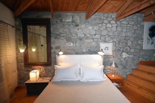 a bedroom with a large bed with a stone wall at Salkimi in Mithymna