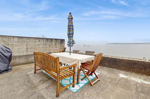 a table with chairs and a umbrella on top of a wall at Oceanfront Beauty in Blaine