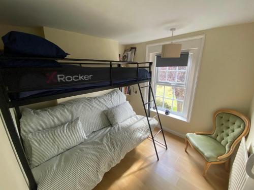 a bedroom with a bunk bed and a couch at Spacious 6-Bed Countryside Home Surrounded by Nature in Sutton Bridge