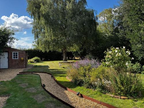 a garden with a curvy path in the grass at Spacious 6-Bed Countryside Home Surrounded by Nature in Sutton Bridge