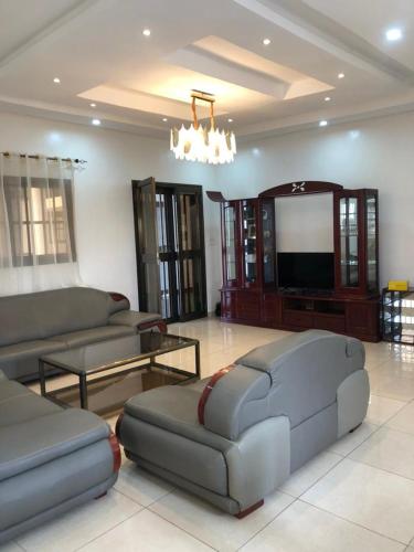 a living room with couches and a flat screen tv at Appartement Haut Standing in Lomé