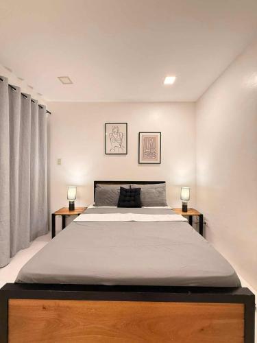 Un dormitorio con una cama grande con dos lámparas sobre mesas. en Jodies Place Near Airport Cozy Homestay, en Puerto Princesa City