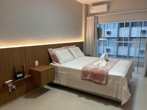 a bedroom with a bed with a stuffed animal on it at Areia Flat vista mar piscina e ar in Guarapari