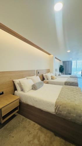 two beds in a large room with at Cardedeu Residence Cangrejera in La Libertad