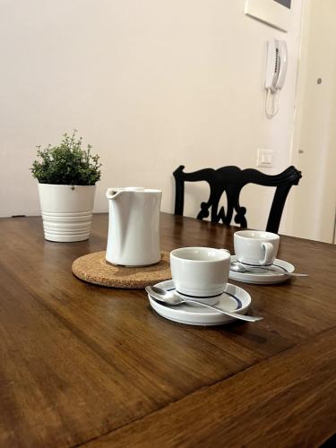 a wooden table with two cups and plates on it at Studio di Lilli in Venice