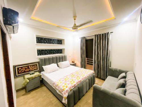 a bedroom with a bed and a couch at Sahiwal family Guest house in Gurmukh Singhwāla