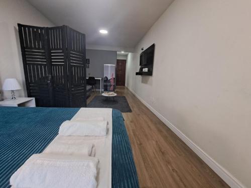 a bedroom with two beds and a flat screen tv at Lindo Studio Largo da Carioca Metrô VLT Lapa in Rio de Janeiro