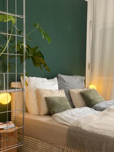 a couch with pillows in a room with a green wall at Penthouse - Designer Wohnung mit Terrasse und Tiefgarage in Hochheim am Main