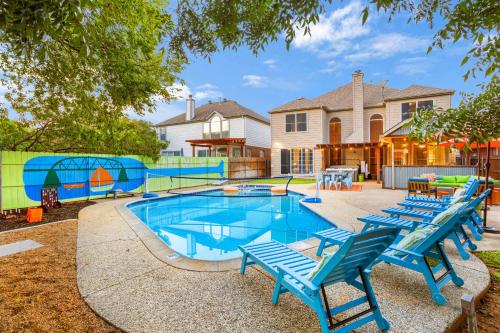 a pool with blue chairs and a playground at Resort Style Backyard Pool Pickleball Court in Lake Dallas