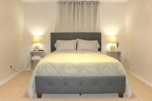 a bedroom with a large bed with two lamps at Home beside WEM in Edmonton