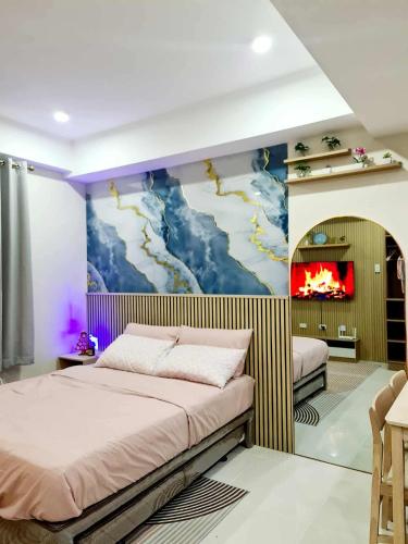 a bedroom with two beds and a painting on the wall at HarborPoint Mactan in Mactan