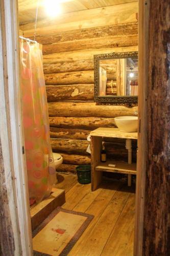 a bathroom with a toilet and a sink in a log cabin at ecoturístico montaña viviente , CABAÑA CHALCHOAPAN in Acaxochitlán