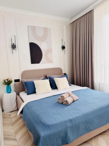 una camera da letto con un letto grande con una coperta blu di Квартира посуточно a Shymkent