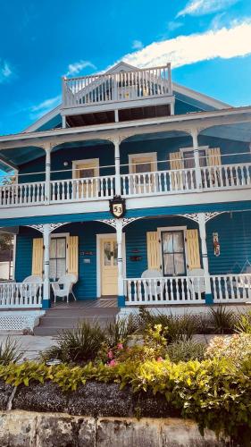 a blue house with a white porch and balcony at Historic Luxury Two Bedroom Apartment in St. Augustine