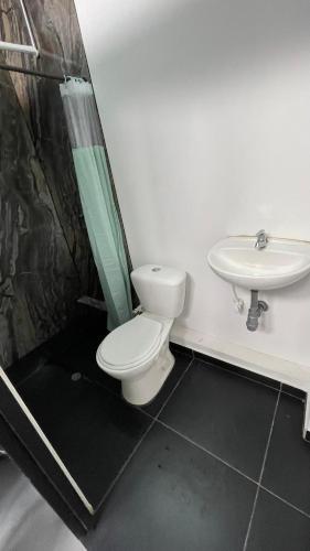 a bathroom with a toilet and a sink at Hotel Cápsula Bogotá Castellana in Bogotá